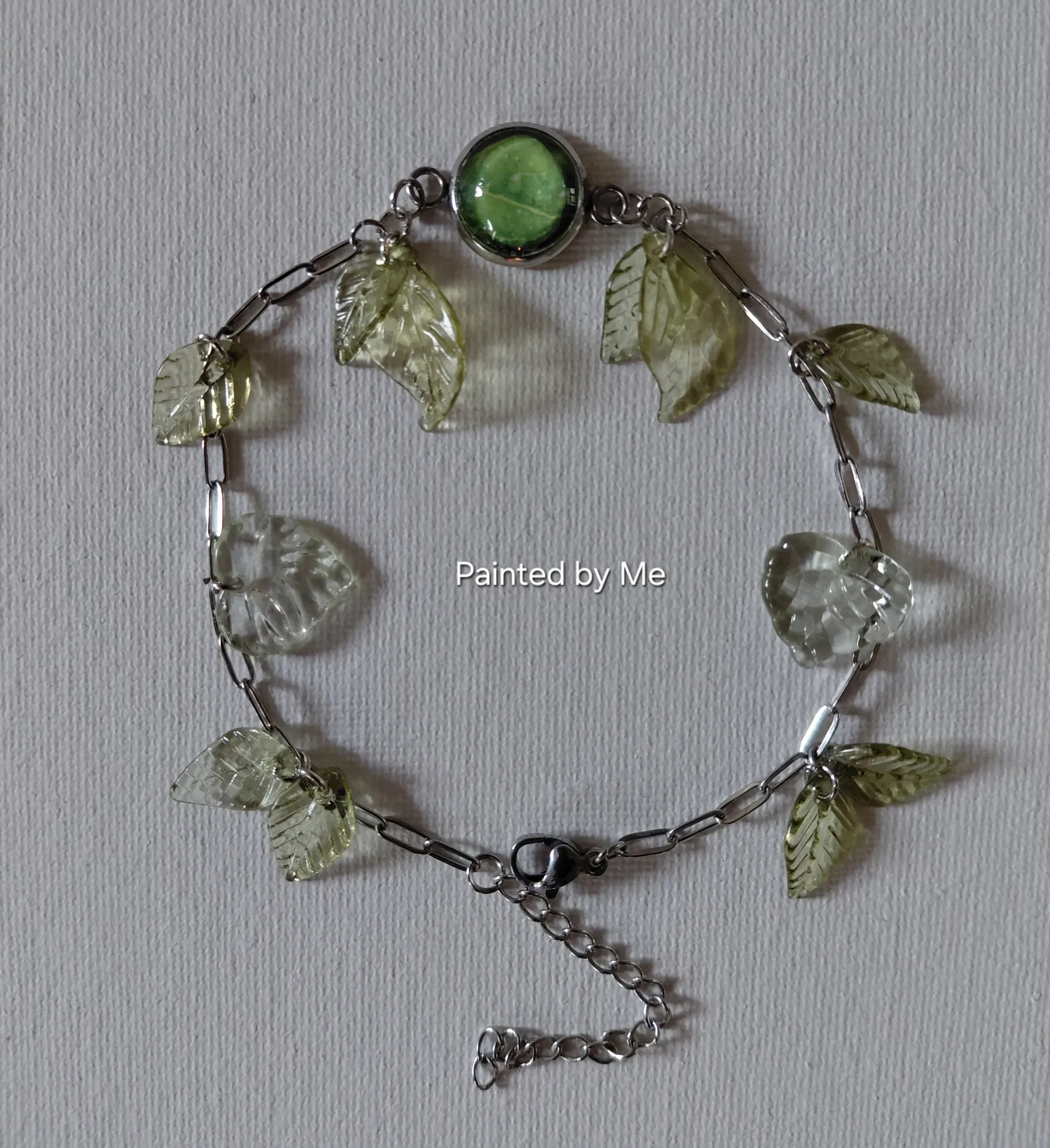 Zilverkleurige armband handgemaakt met blaadjes mini bedeltjes doorsnee cabochon 12 mm, mixed green